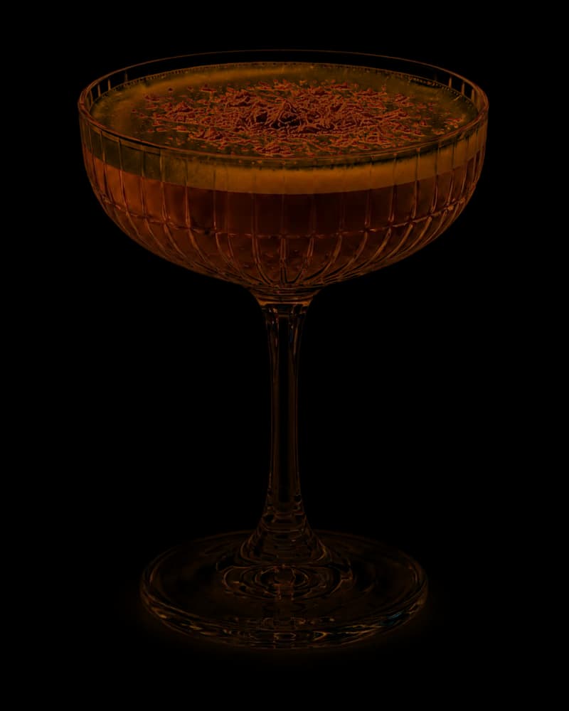 Midnight Soufflé dessert cocktail in a ribbed coupe with a creamy espresso foam cap and grated dark chocolate.