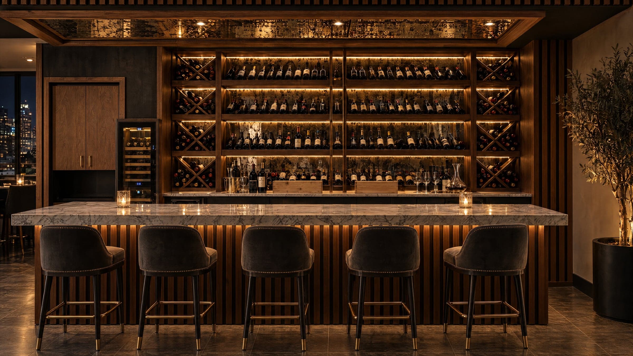 The Alamo Prime wine bar at night, with backlit shelves of bottles, a marble counter and velvet bar stools.